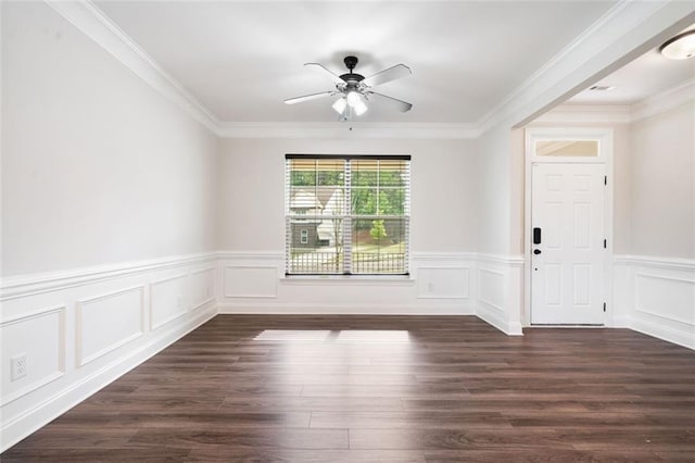 spare room featuring ceiling fan, a wainscoted wall, dark wood-style flooring, and ornamental molding