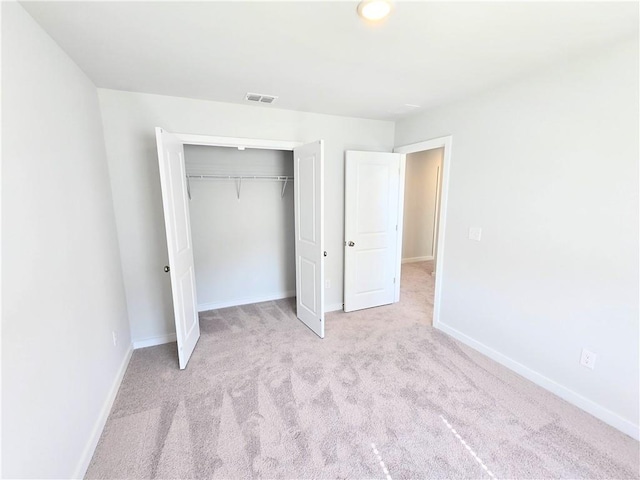 unfurnished bedroom featuring carpet, a closet, visible vents, and baseboards