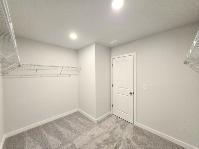 walk in closet featuring light carpet and visible vents