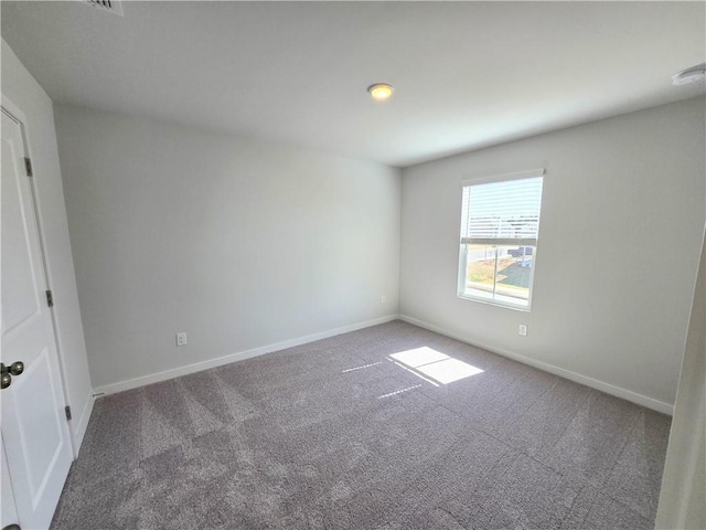 carpeted empty room featuring baseboards