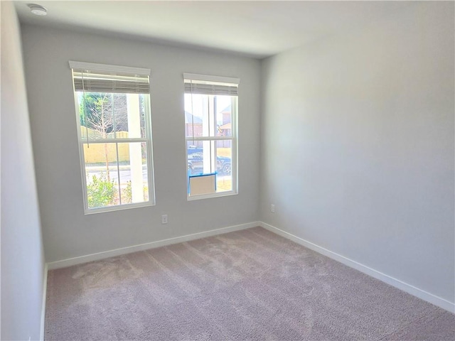 unfurnished room with carpet floors and baseboards