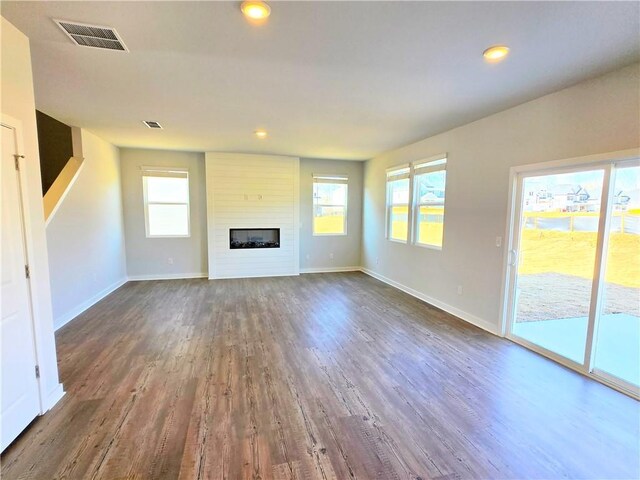 kitchen with sink, white cabinetry, appliances with stainless steel finishes, light stone countertops, and a kitchen island with sink