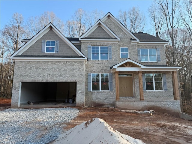 craftsman-style house featuring a garage and brick siding