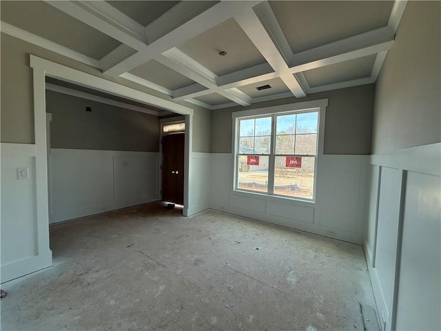 spare room featuring beamed ceiling, wainscoting, and coffered ceiling