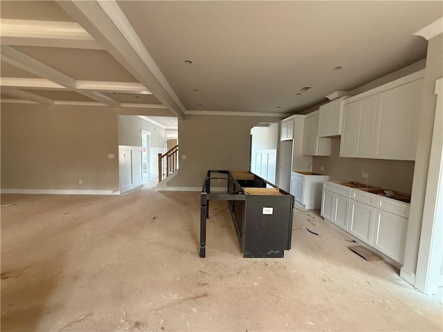 kitchen with white cabinets, a kitchen island, a kitchen bar, and baseboards