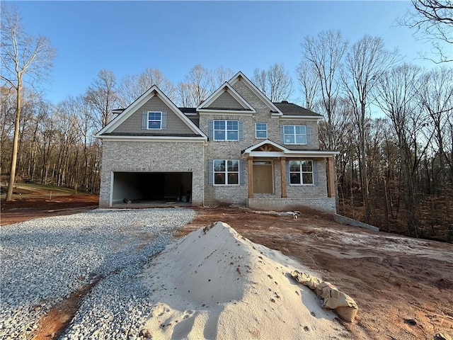 view of front of home featuring a garage and gravel driveway