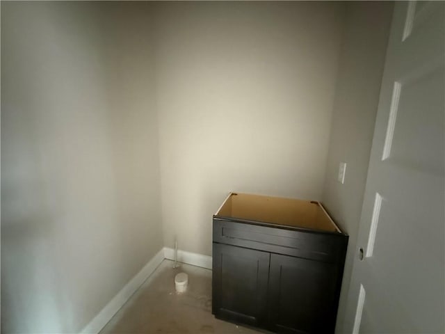 bathroom featuring unfinished concrete floors and baseboards