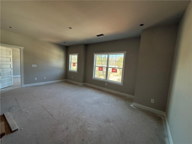 unfurnished room featuring visible vents and baseboards