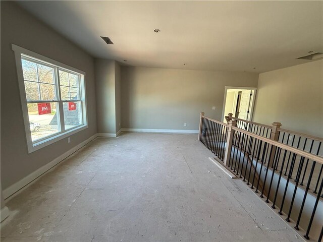 hallway featuring visible vents, an upstairs landing, and baseboards