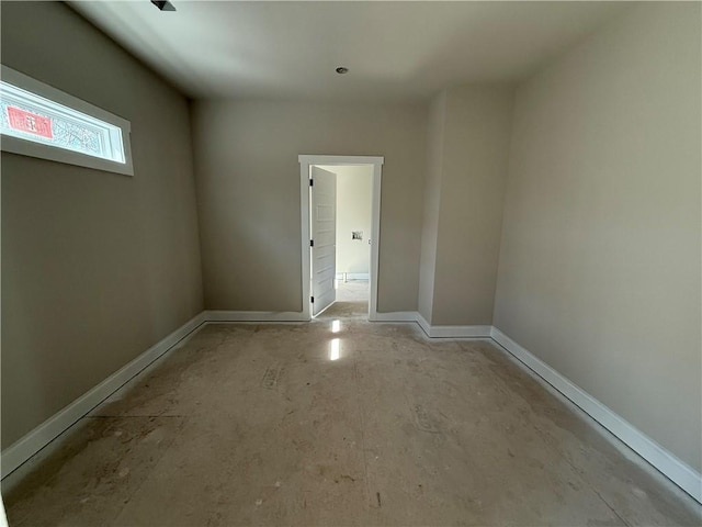 unfurnished room with baseboards