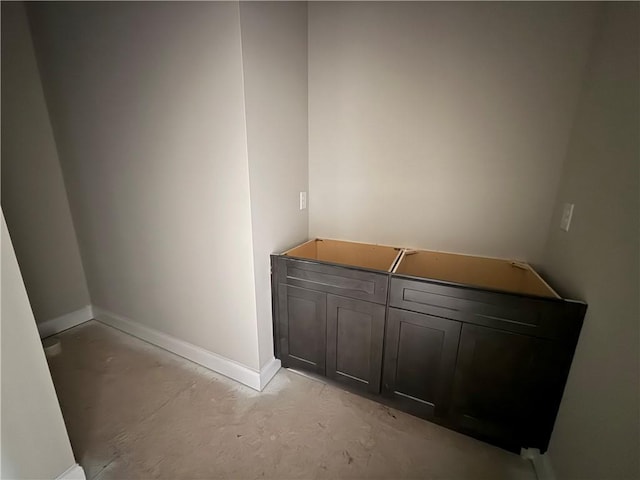 interior space featuring baseboards and concrete flooring