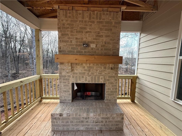 deck with an outdoor brick fireplace