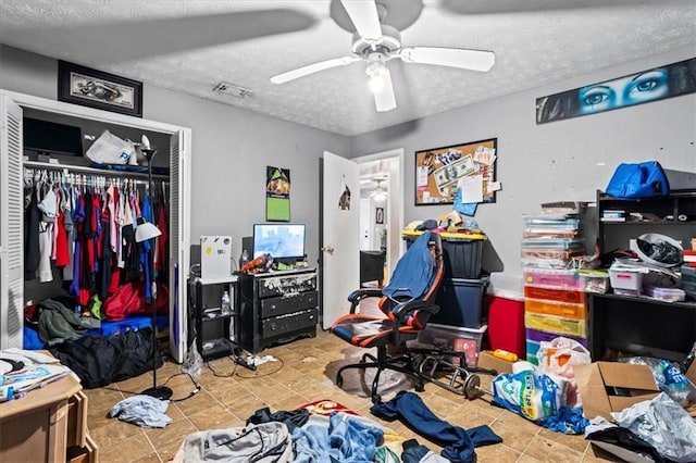 bedroom featuring ceiling fan, a closet, and a textured ceiling