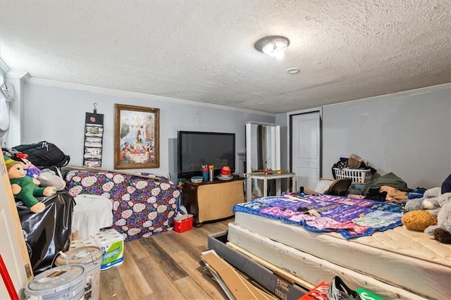 bedroom with hardwood / wood-style flooring, crown molding, and a textured ceiling