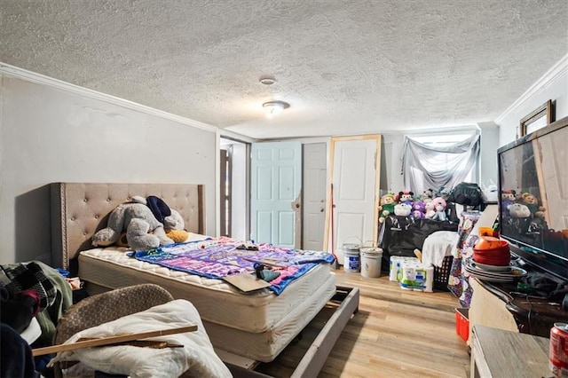 bedroom with crown molding, a textured ceiling, and light wood-type flooring