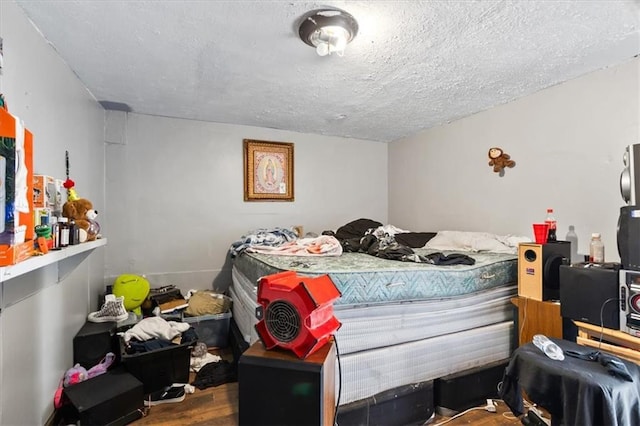 bedroom with wood-type flooring and a textured ceiling