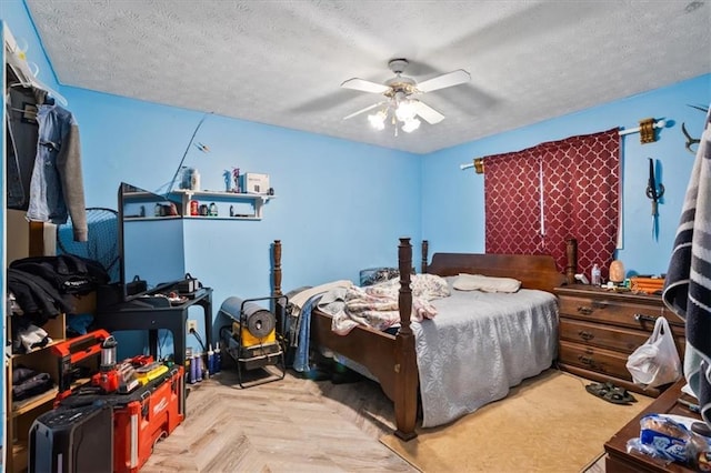 bedroom featuring ceiling fan, a textured ceiling, and light parquet flooring