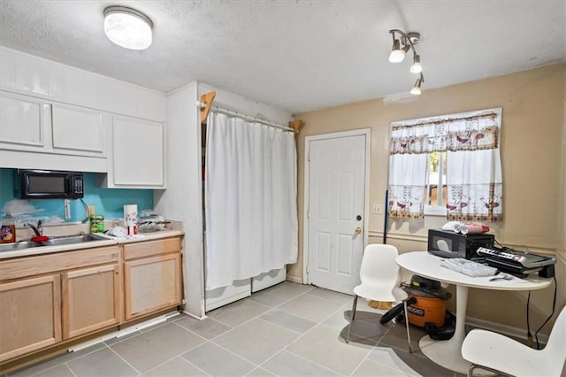 3131 Ferrite Ct, Lawrenceville, GA 30044 - kitchen featuring light tile patterned flooring, a textured ceiling, light countertops, black microwave, and a sink