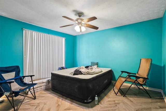 bedroom featuring light parquet flooring, a textured ceiling, and ceiling fan