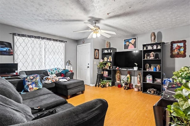 living room with wood-type flooring, ceiling fan, and a textured ceiling