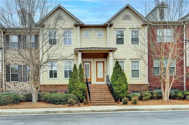 townhome / multi-family property with brick siding, metal roof, and a standing seam roof