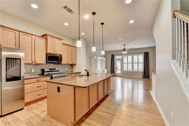 kitchen with light brown cabinets, visible vents, a sink, stainless steel appliances, and backsplash