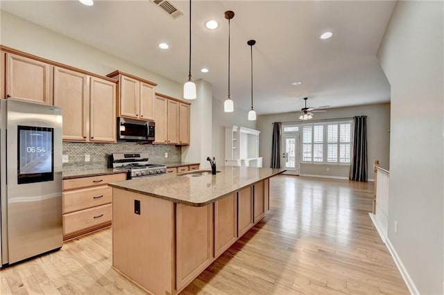 kitchen featuring light brown cabinets, visible vents, a sink, appliances with stainless steel finishes, and tasteful backsplash