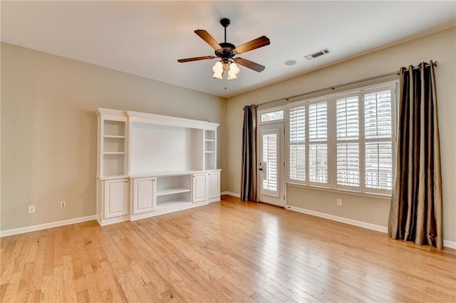 unfurnished room featuring a ceiling fan, baseboards, visible vents, and light wood finished floors