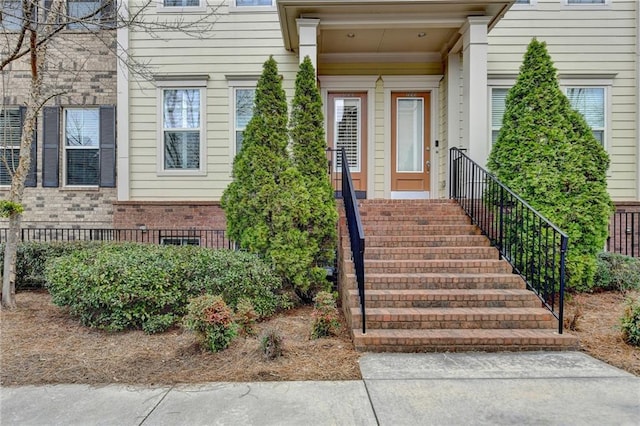 entrance to property featuring brick siding