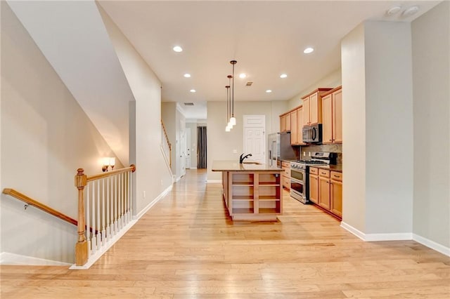 kitchen featuring baseboards, a center island with sink, decorative backsplash, appliances with stainless steel finishes, and light wood-style floors