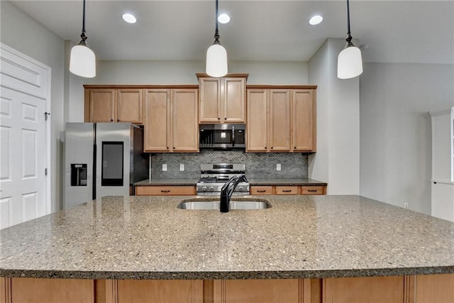 kitchen with an island with sink, decorative backsplash, stone counters, stainless steel appliances, and a sink