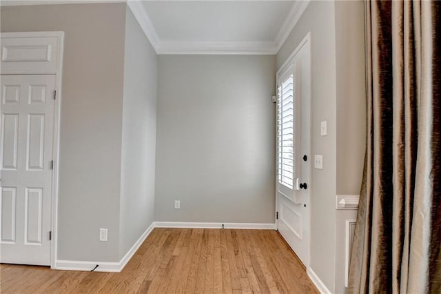 entrance foyer with crown molding, baseboards, and light wood-type flooring