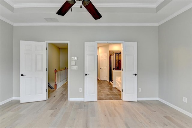 unfurnished bedroom with crown molding, baseboards, and light wood-type flooring