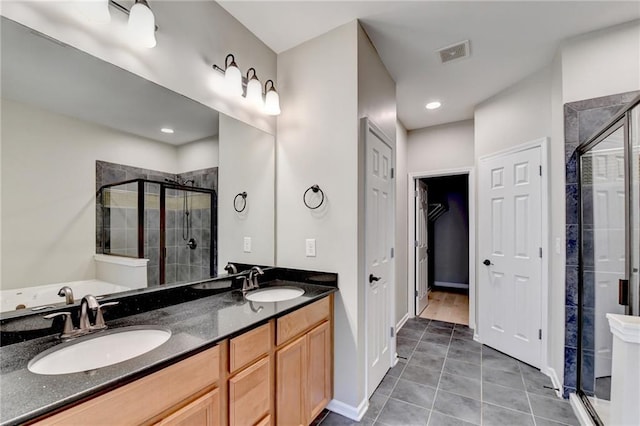 full bathroom with double vanity, visible vents, a shower stall, and a sink