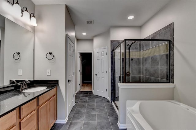 bathroom featuring visible vents, a shower stall, vanity, and a garden tub