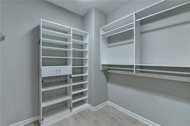 walk in closet with wood finished floors