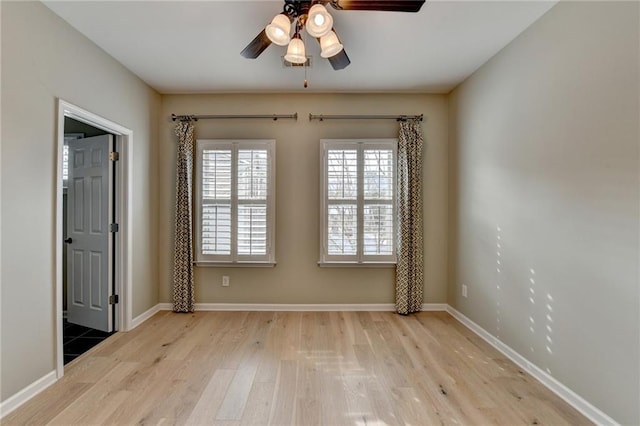 unfurnished room featuring ceiling fan, baseboards, and wood finished floors