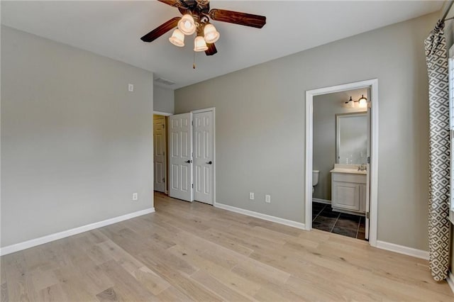 unfurnished bedroom featuring visible vents, connected bathroom, baseboards, ceiling fan, and light wood-style floors