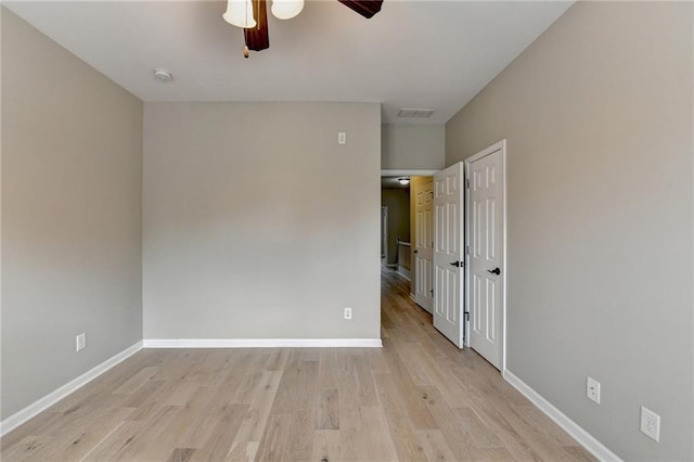 unfurnished bedroom featuring ceiling fan, visible vents, baseboards, and light wood-type flooring