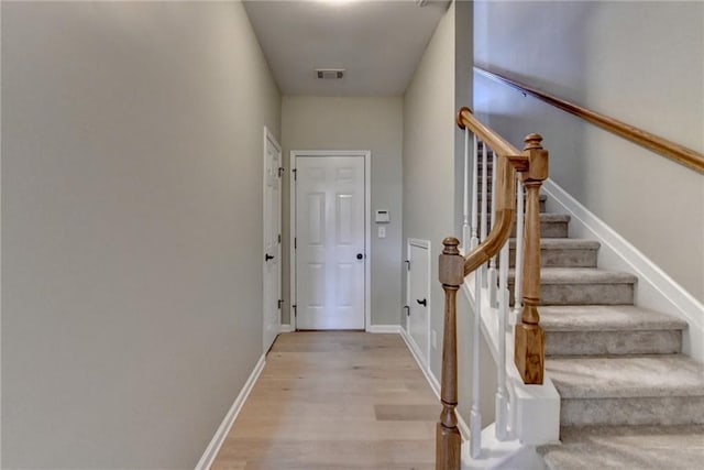 interior space with stairs, visible vents, light wood-style floors, and baseboards