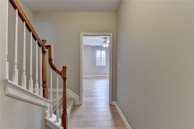 stairway with wood finished floors and baseboards