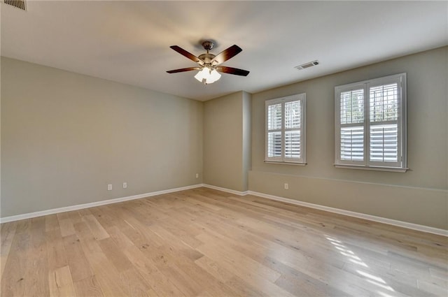 unfurnished room with ceiling fan, visible vents, baseboards, and light wood-style flooring