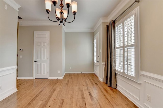 unfurnished dining area with a notable chandelier, plenty of natural light, and ornamental molding