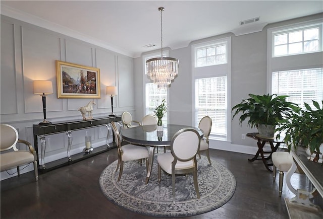 dining space with an inviting chandelier, ornamental molding, and dark hardwood / wood-style floors