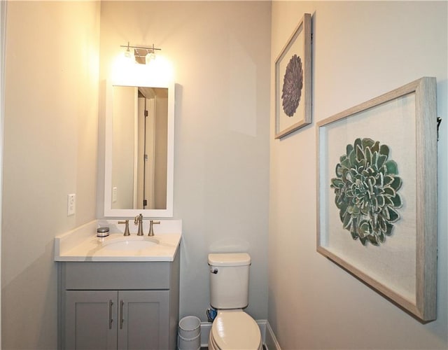 bathroom with toilet and vanity with extensive cabinet space