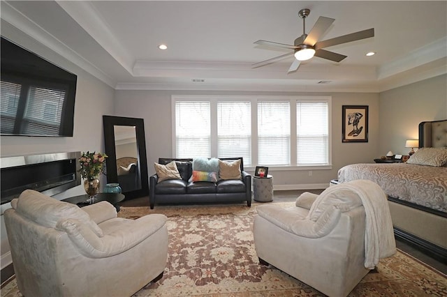 bedroom with ceiling fan and a raised ceiling