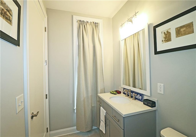 bathroom with tile floors, large vanity, and toilet