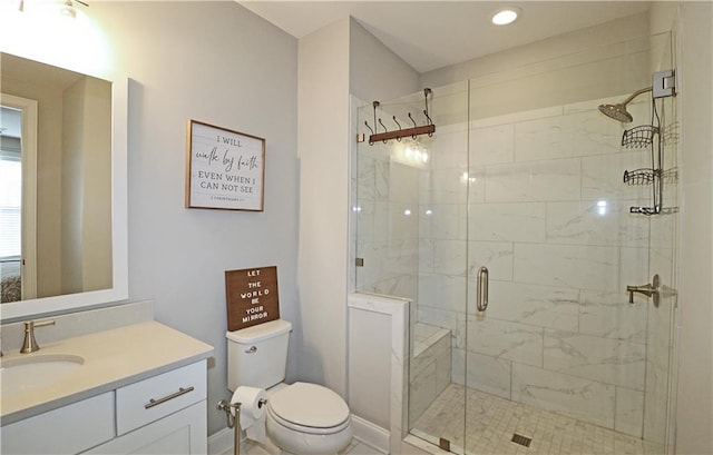 bathroom featuring toilet, vanity, and a shower with shower door