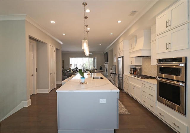 kitchen featuring light stone countertops, dark hardwood / wood-style floors, a kitchen island with sink, premium range hood, and white cabinets