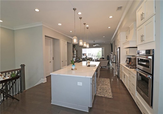 kitchen with pendant lighting, custom exhaust hood, a center island with sink, white cabinetry, and dark hardwood / wood-style floors